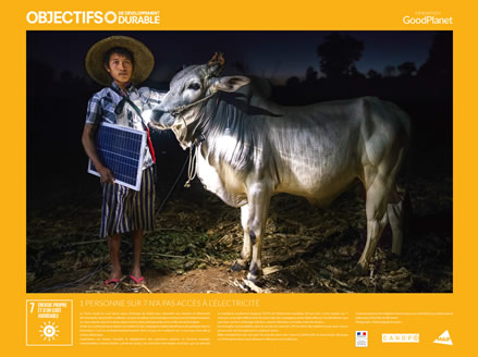 Un jeune paysan d'une vingtaine d'années pose avec son bétail et un petit panneau solaire dans l'état Shan en Birmanie.